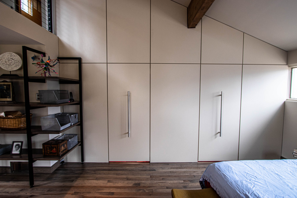 Foto de dormitorio tipo loft vintage grande con paredes beige, suelo de madera en tonos medios y suelo marrón
