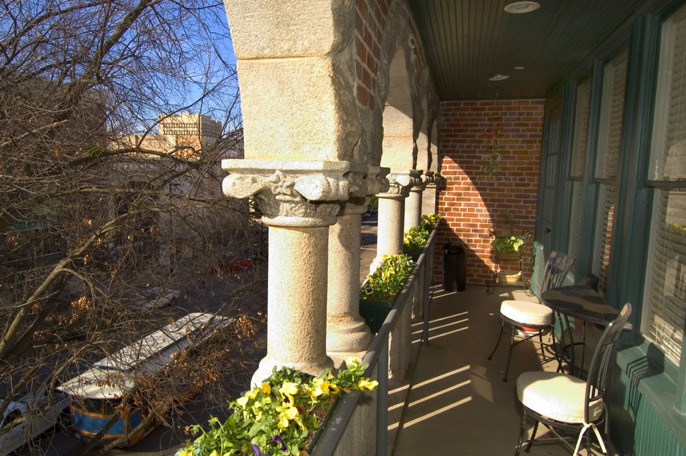 Inspiration for a mid-sized eclectic front yard verandah in Charleston with with columns and a roof extension.
