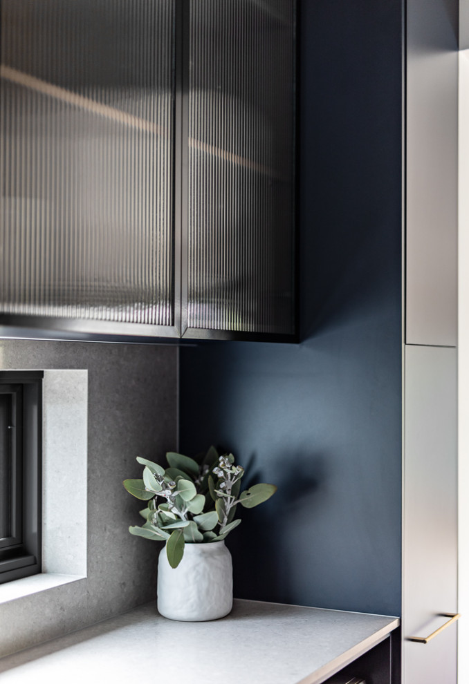 Photo of a mid-sized contemporary galley separate kitchen in Sydney with a double-bowl sink, blue cabinets, quartz benchtops, grey splashback, engineered quartz splashback, stainless steel appliances, medium hardwood floors, no island, brown floor and grey benchtop.