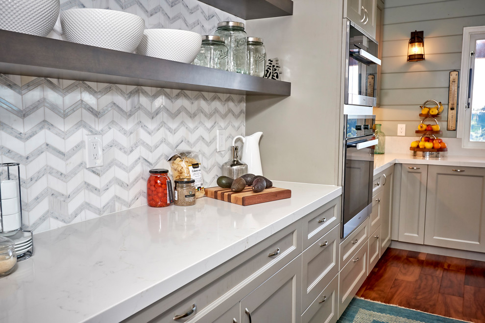Example of a large transitional l-shaped medium tone wood floor and brown floor open concept kitchen design in Denver with an undermount sink, recessed-panel cabinets, gray cabinets, quartz countertops, white backsplash, marble backsplash, stainless steel appliances, an island and white countertops