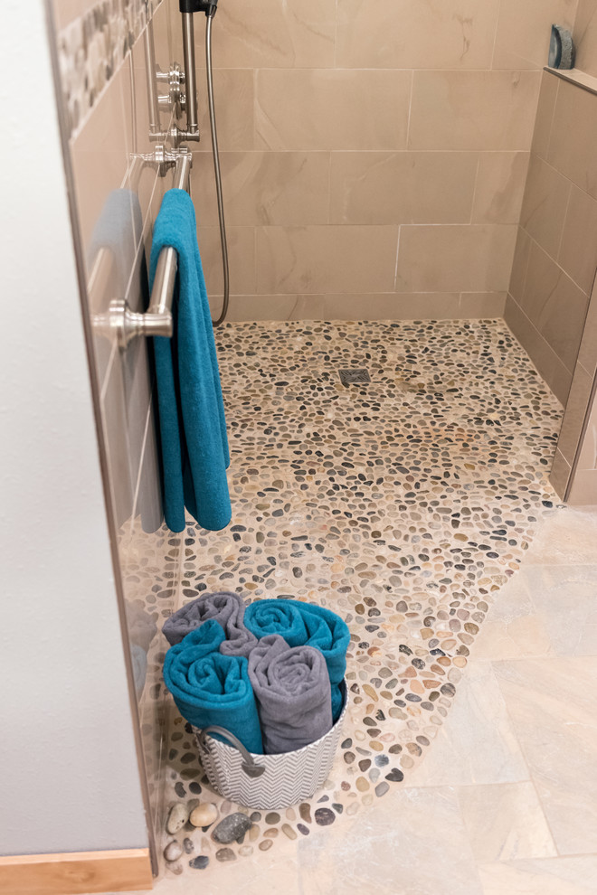 Photo of a large transitional master bathroom in Milwaukee with a curbless shower, beige tile, porcelain tile, beige walls and pebble tile floors.