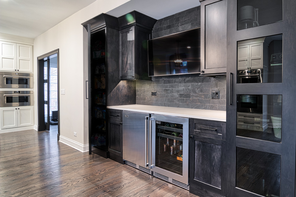 Example of a large transitional u-shaped medium tone wood floor and brown floor kitchen pantry design in Nashville with an undermount sink, shaker cabinets, dark wood cabinets, black backsplash, brick backsplash, stainless steel appliances, an island and white countertops