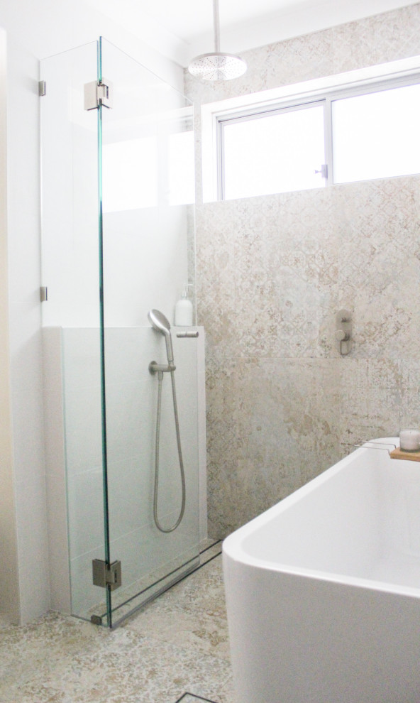 Inredning av ett modernt litet vit vitt badrum med dusch, med släta luckor, vita skåp, ett fristående badkar, våtrum, flerfärgad kakel, porslinskakel, ett fristående handfat, bänkskiva i kvarts och med dusch som är öppen