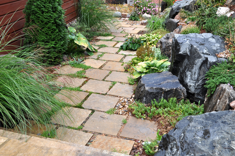 Inspiration for a traditional backyard garden in Denver with natural stone pavers.