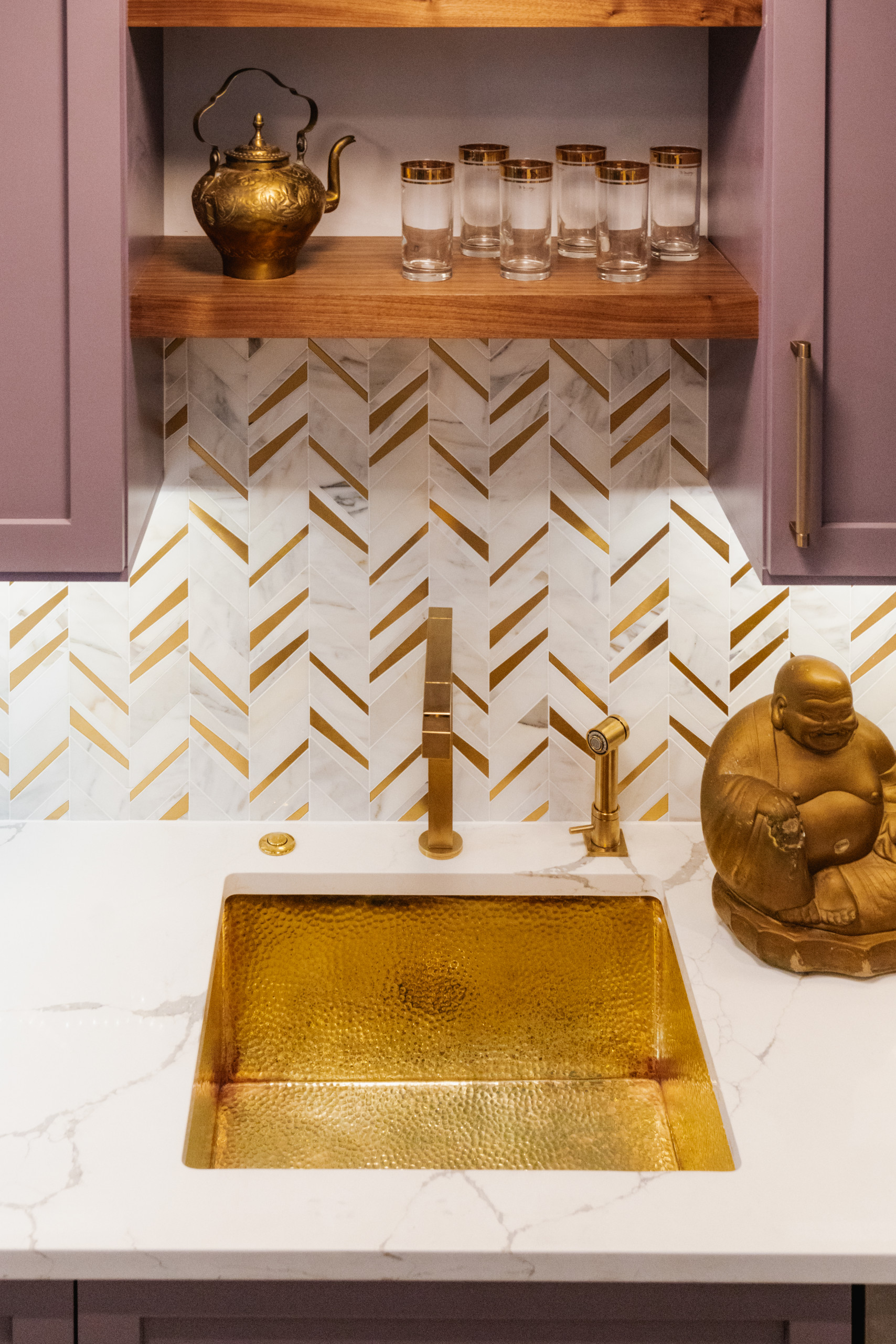Hammered brass sink and marble backsplash