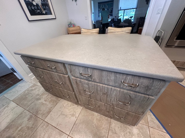 Example of a large l-shaped eat-in kitchen design with an undermount sink, flat-panel cabinets, medium tone wood cabinets, stainless steel appliances and an island