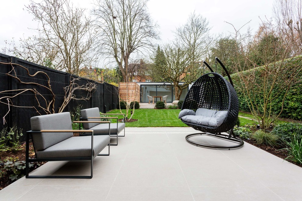 Photo of a large contemporary backyard patio in London with no cover.