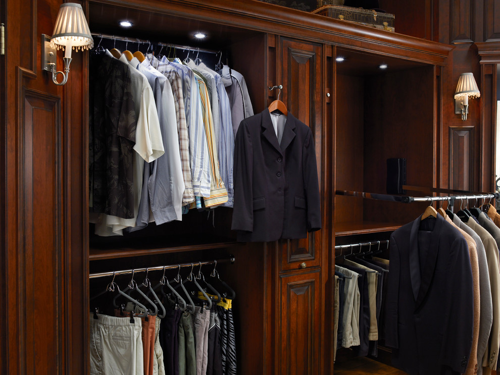 Inspiration for a mid-sized traditional men's walk-in wardrobe in Houston with raised-panel cabinets and dark wood cabinets.