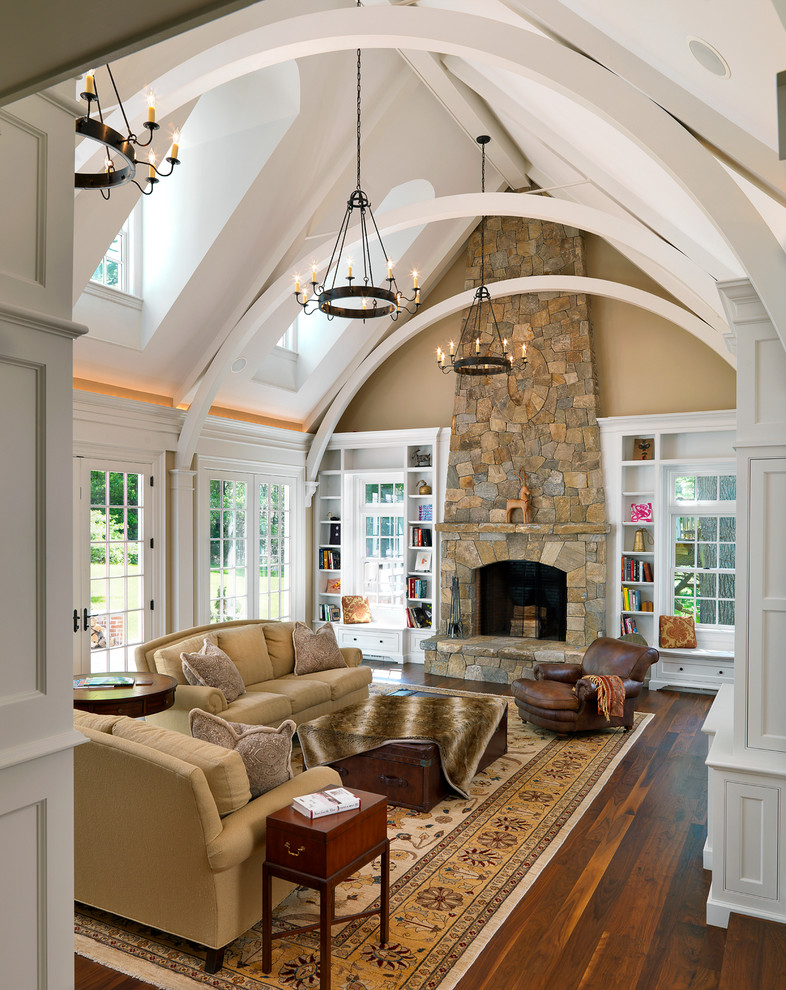 Design ideas for a traditional family room in Boston with beige walls, dark hardwood floors, a standard fireplace and a stone fireplace surround.