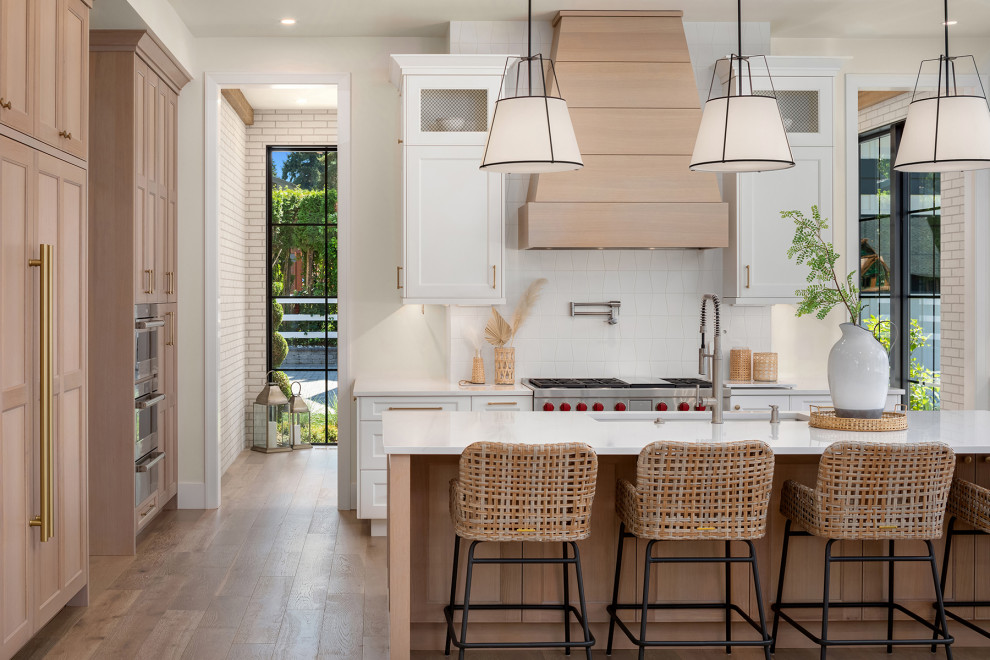 Example of a transitional light wood floor kitchen design in Seattle with recessed-panel cabinets, light wood cabinets, quartz countertops, white backsplash, porcelain backsplash, paneled appliances and white countertops