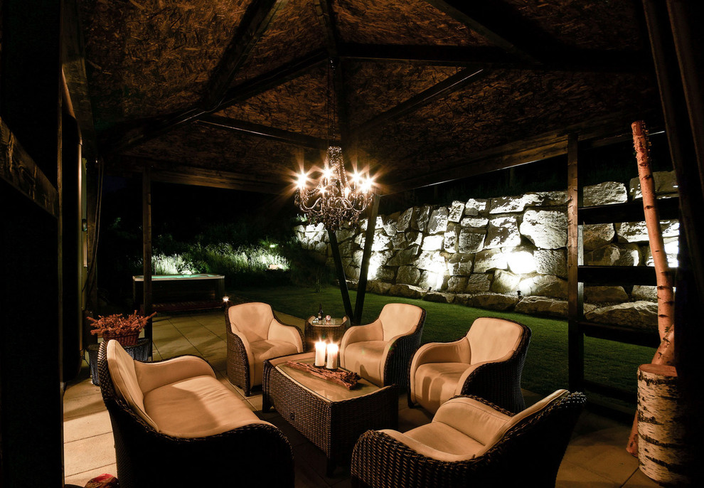 Mittelgroße, Überdachte Klassische Terrasse neben dem Haus mit Feuerstelle in Sonstige