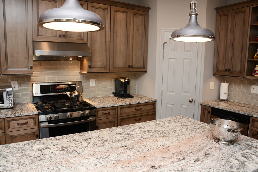 This is an example of a mid-sized country l-shaped eat-in kitchen in Baltimore with a double-bowl sink, recessed-panel cabinets, grey cabinets, granite benchtops, grey splashback, stainless steel appliances, medium hardwood floors and with island.
