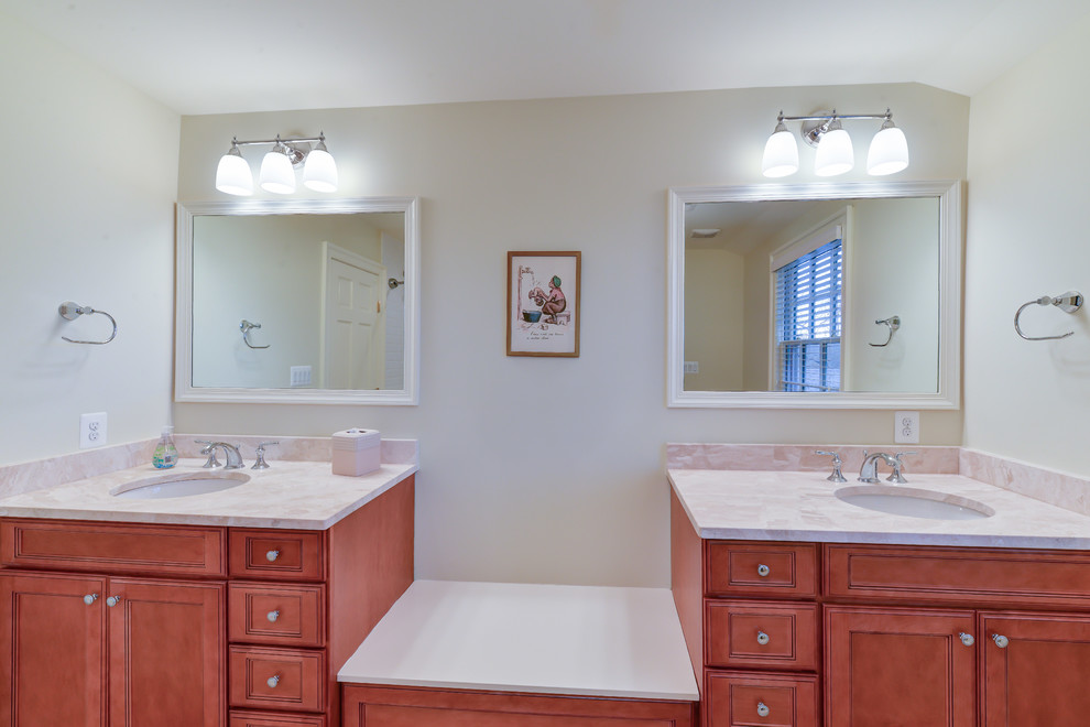 Inspiration for a mid-sized traditional kids bathroom with an integrated sink, recessed-panel cabinets, medium wood cabinets, granite benchtops, a two-piece toilet, beige tile, ceramic tile, beige walls and ceramic floors.