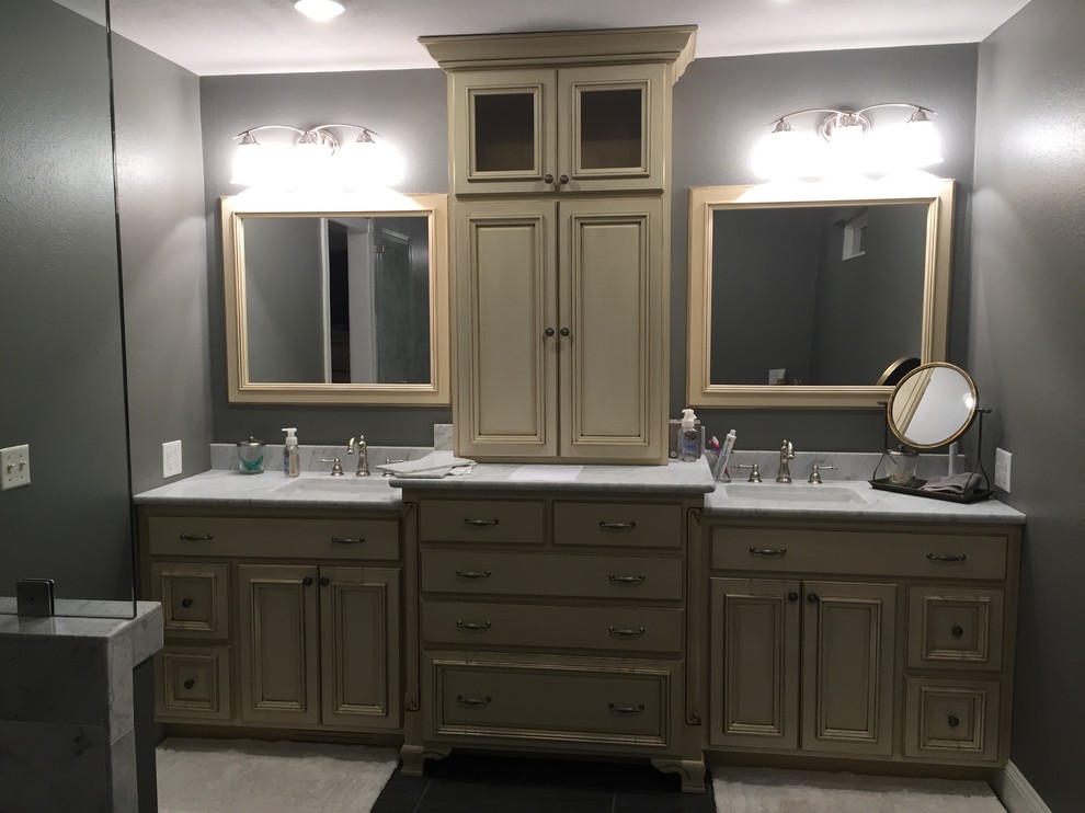 Large transitional master medium tone wood floor and gray floor bathroom photo in Orange County with flat-panel cabinets, gray cabinets, white walls, a vessel sink, marble countertops and white countertops