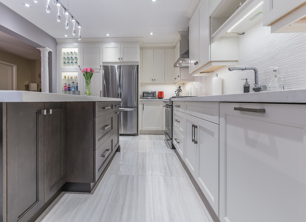 Mid-sized transitional l-shaped porcelain tile eat-in kitchen photo in Toronto with a drop-in sink, recessed-panel cabinets, white cabinets, quartz countertops, stainless steel appliances and an island