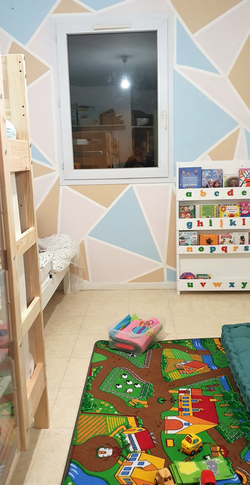 This is an example of a small modern gender-neutral kids' room in Paris with multi-coloured walls, vinyl floors and beige floor.