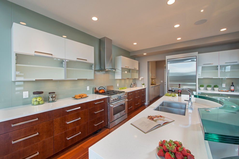Mid-sized modern l-shaped eat-in kitchen in Vancouver with flat-panel cabinets, yellow cabinets, green splashback, stainless steel appliances, light hardwood floors and with island.