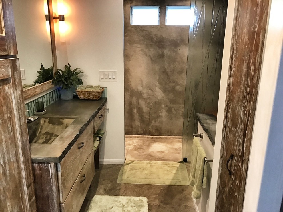 Design ideas for a mid-sized country master bathroom in Hawaii with flat-panel cabinets, distressed cabinets, a curbless shower, concrete floors, an integrated sink, concrete benchtops and an open shower.