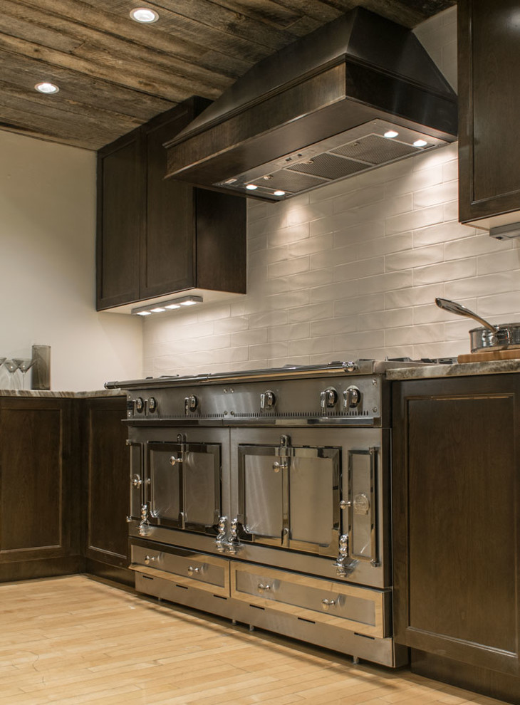 Kitchen - transitional light wood floor kitchen idea in Boston with dark wood cabinets, granite countertops, white backsplash, subway tile backsplash and stainless steel appliances