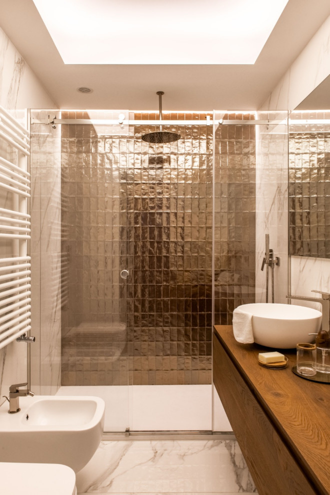 This is an example of a mid-sized eclectic 3/4 bathroom in Catania-Palermo with flat-panel cabinets, dark wood cabinets, a curbless shower, a wall-mount toilet, white tile, marble, white walls, marble floors, a vessel sink, wood benchtops, white floor, a sliding shower screen, white benchtops, a single vanity, a floating vanity, recessed and brick walls.