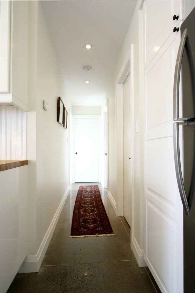 Mid-sized transitional concrete floor hallway photo in Toronto with white walls