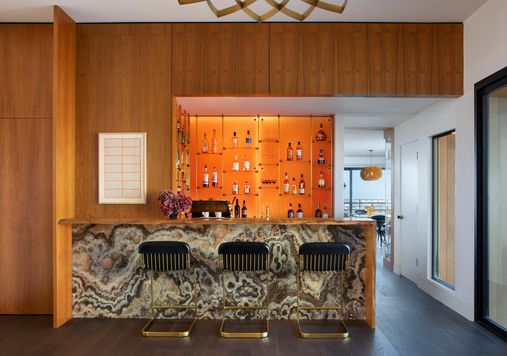 Photo of a contemporary galley home bar in San Francisco with flat-panel cabinets, medium wood cabinets, wood benchtops, orange splashback, dark hardwood floors, brown floor and brown benchtop.