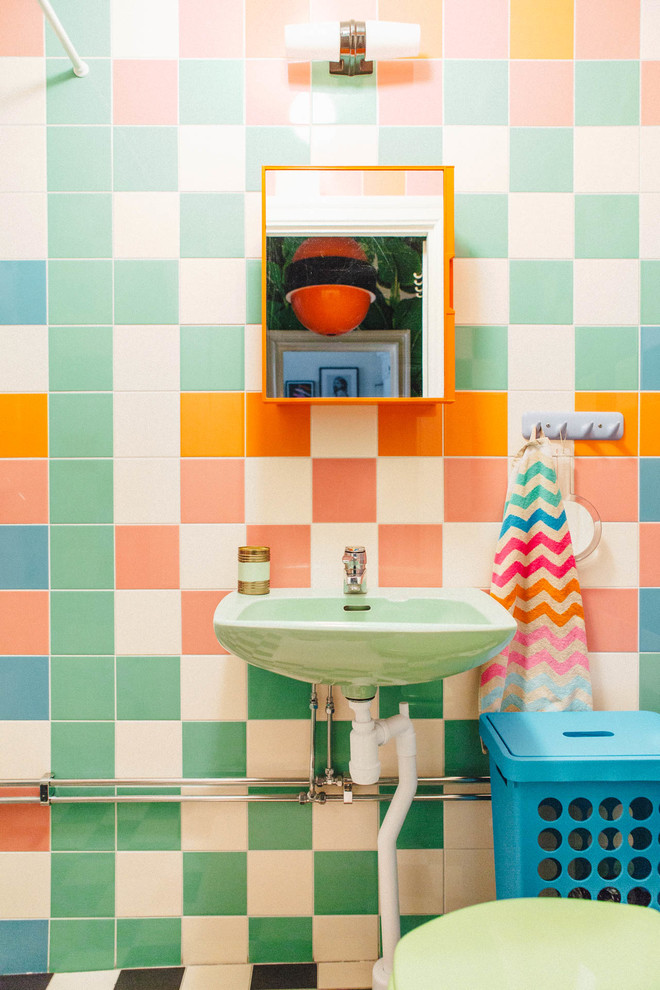 Photo of an eclectic powder room in Stockholm with green tile, orange tile, pink tile, white tile and multi-coloured walls.