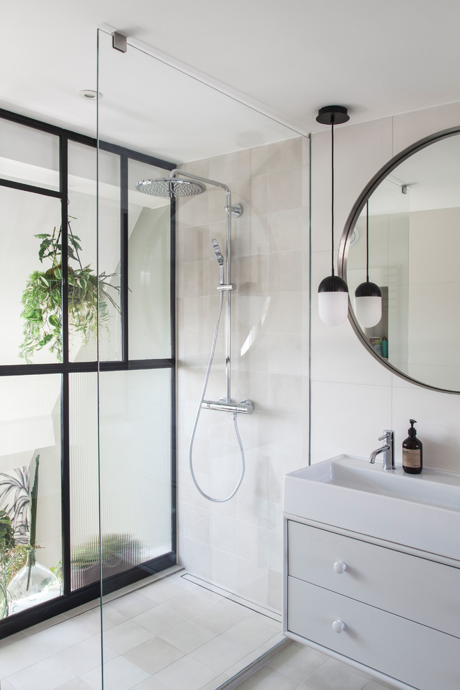 Photo of a mid-sized contemporary master bathroom in Paris with flat-panel cabinets, grey cabinets, an open shower, beige tile, ceramic tile, white walls, ceramic floors, a trough sink, solid surface benchtops, beige floor, a hinged shower door, white benchtops, a double vanity and a floating vanity.