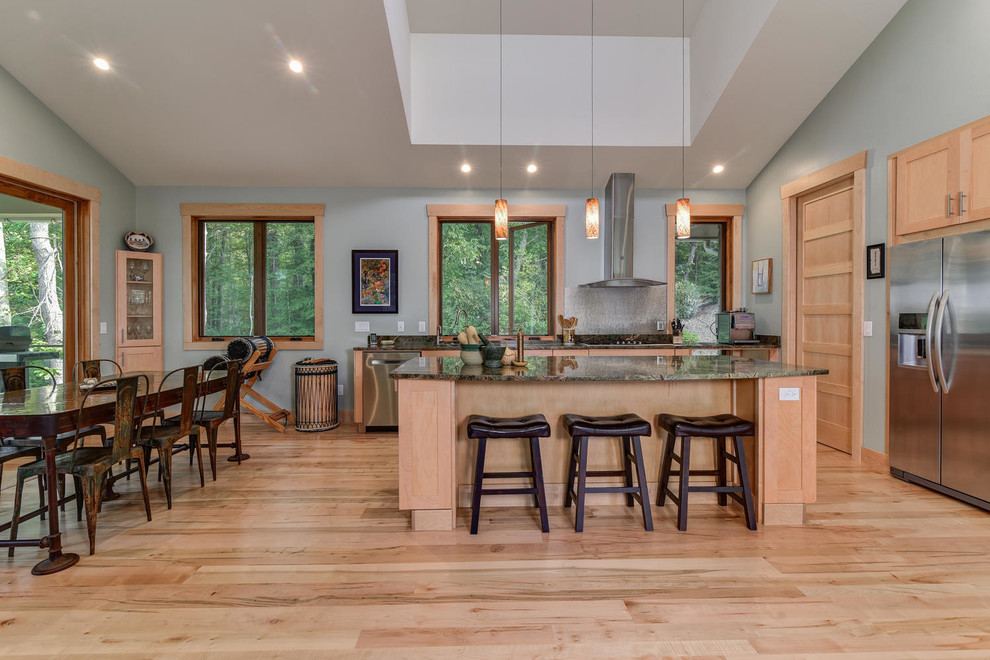 Open concept kitchen - mid-sized eclectic galley light wood floor open concept kitchen idea with an undermount sink, light wood cabinets, granite countertops, stainless steel appliances and an island