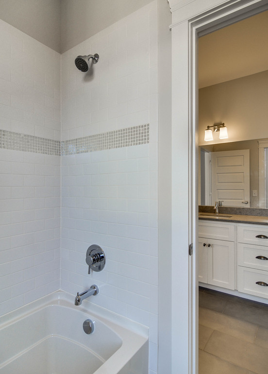 Photo of a large traditional master bathroom in Nashville with shaker cabinets, white cabinets, an alcove tub, a shower/bathtub combo, white tile, subway tile, beige walls, ceramic floors, an undermount sink, engineered quartz benchtops, brown floor, a shower curtain and brown benchtops.