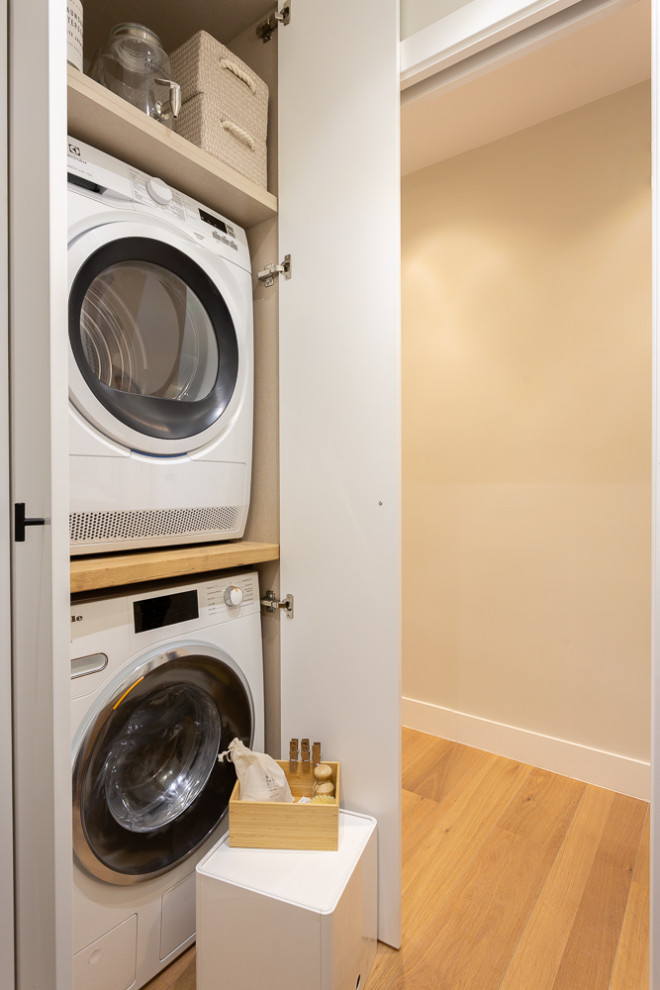 Idee per un piccolo ripostiglio-lavanderia classico con pavimento con piastrelle in ceramica e lavatrice e asciugatrice a colonna