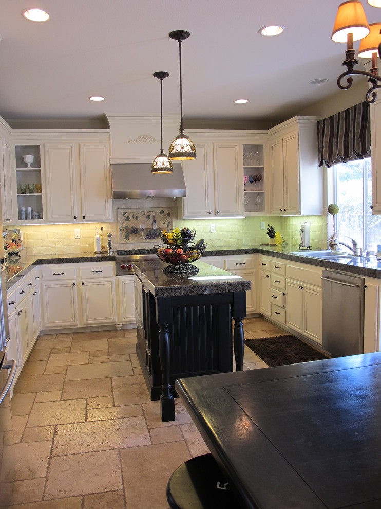 Inspiration for a traditional u-shaped kitchen in San Diego with white cabinets and stainless steel appliances.