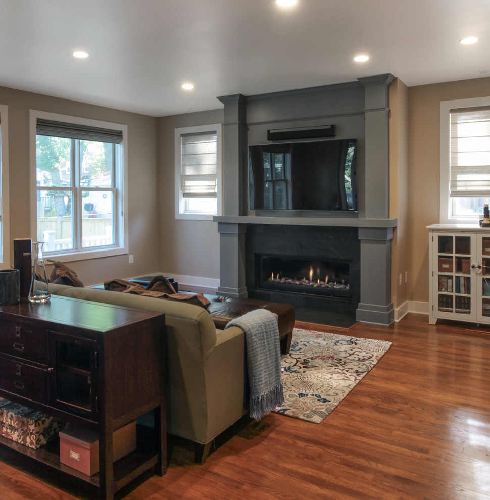 Mid-sized traditional open concept family room in DC Metro with grey walls, dark hardwood floors, a ribbon fireplace, a wood fireplace surround and a built-in media wall.