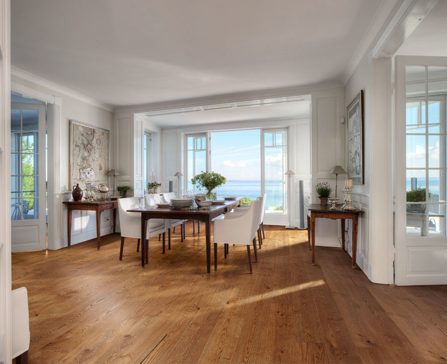 This is an example of a mid-sized beach style separate dining room in Chicago with white walls, medium hardwood floors and no fireplace.