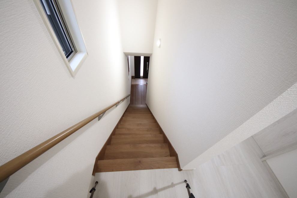 他の地域にある小さなモダンスタイルのおしゃれな階段 (木の蹴込み板、木材の手すり) の写真