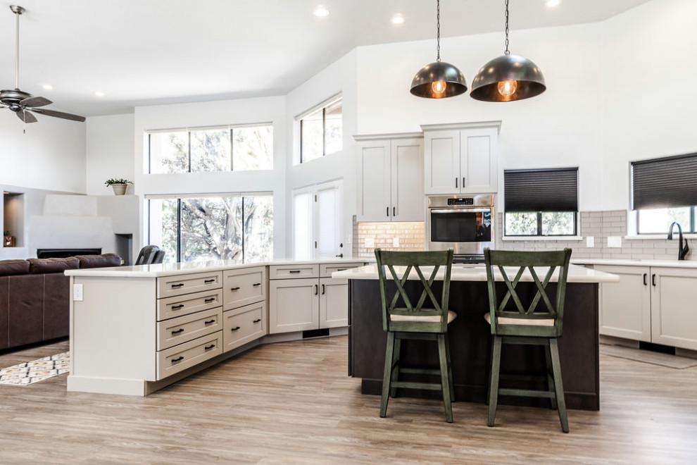 Eat-in kitchen - large transitional u-shaped vinyl floor and gray floor eat-in kitchen idea with an undermount sink, shaker cabinets, gray cabinets, quartzite countertops, green backsplash, subway tile backsplash, stainless steel appliances, an island and white countertops