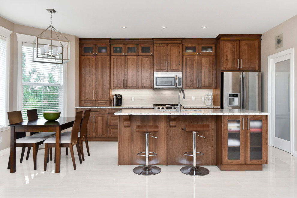Inspiration for a large transitional single-wall porcelain tile open concept kitchen remodel in Calgary with an undermount sink, medium tone wood cabinets, quartz countertops, beige backsplash, stainless steel appliances and an island