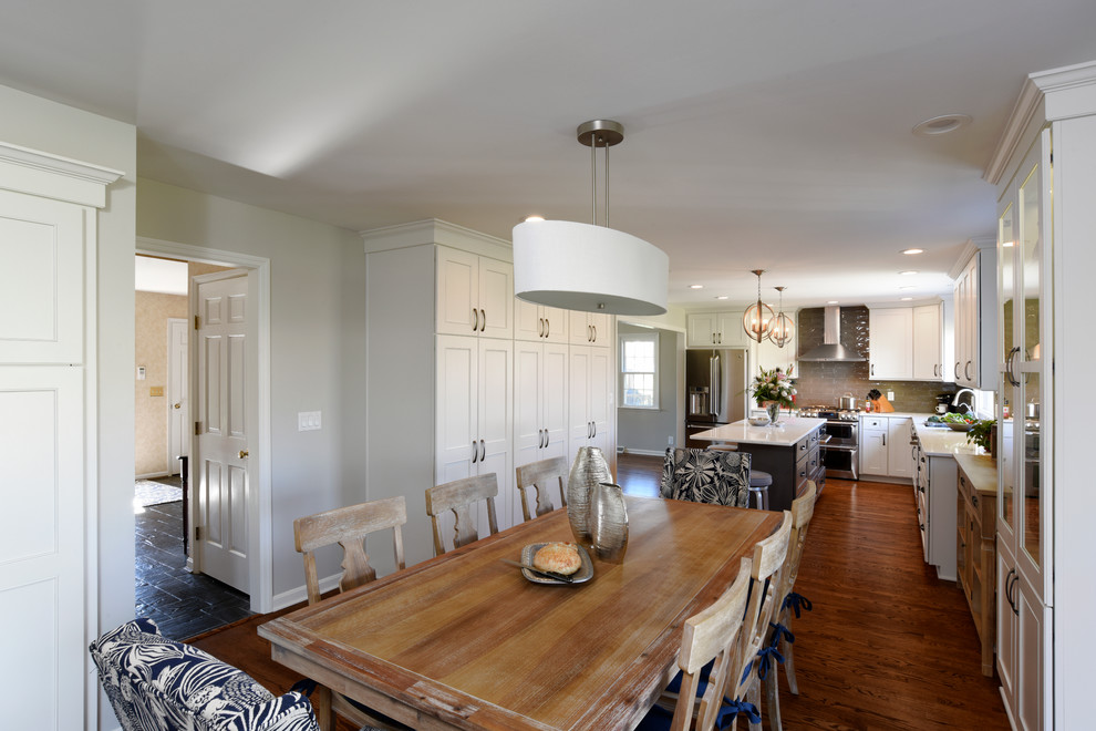 Kitchen/dining room combo - transitional l-shaped medium tone wood floor and brown floor kitchen/dining room combo idea in Orange County with a double-bowl sink, shaker cabinets, white cabinets, marble countertops, gray backsplash, glass tile backsplash, stainless steel appliances and an island
