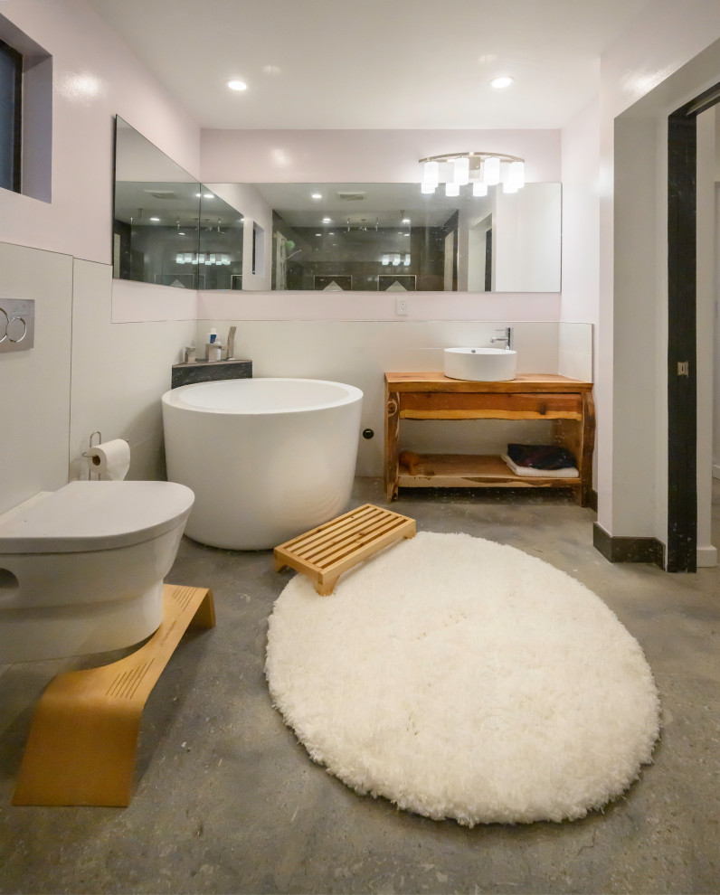 Example of a large mountain style master white tile and ceramic tile gray floor, single-sink and concrete floor bathroom design in Los Angeles with open cabinets, brown cabinets, a one-piece toilet, white walls, a vessel sink, wood countertops, brown countertops and a built-in vanity