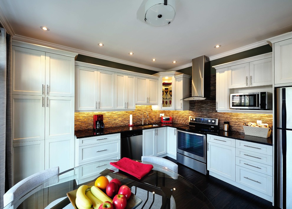 Inspiration for a mid-sized transitional l-shaped dark wood floor and brown floor eat-in kitchen remodel in Ottawa with a single-bowl sink, shaker cabinets, white cabinets, granite countertops, brown backsplash, glass sheet backsplash, stainless steel appliances and no island