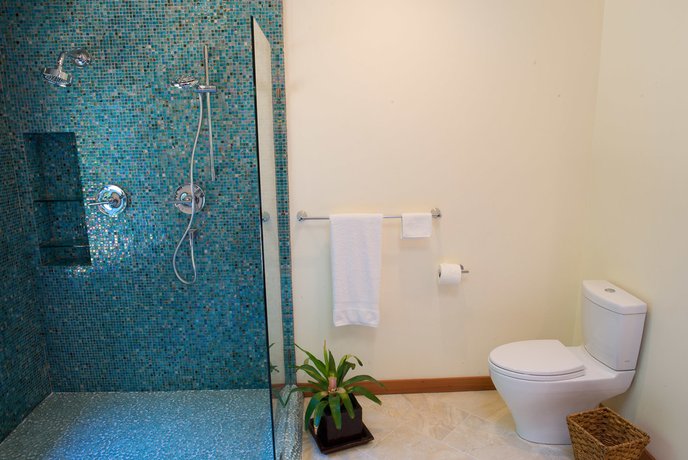 Photo of a mid-sized eclectic master bathroom in Other with flat-panel cabinets, medium wood cabinets, a corner shower, a two-piece toilet, blue tile, glass tile, beige walls, porcelain floors, a vessel sink and wood benchtops.