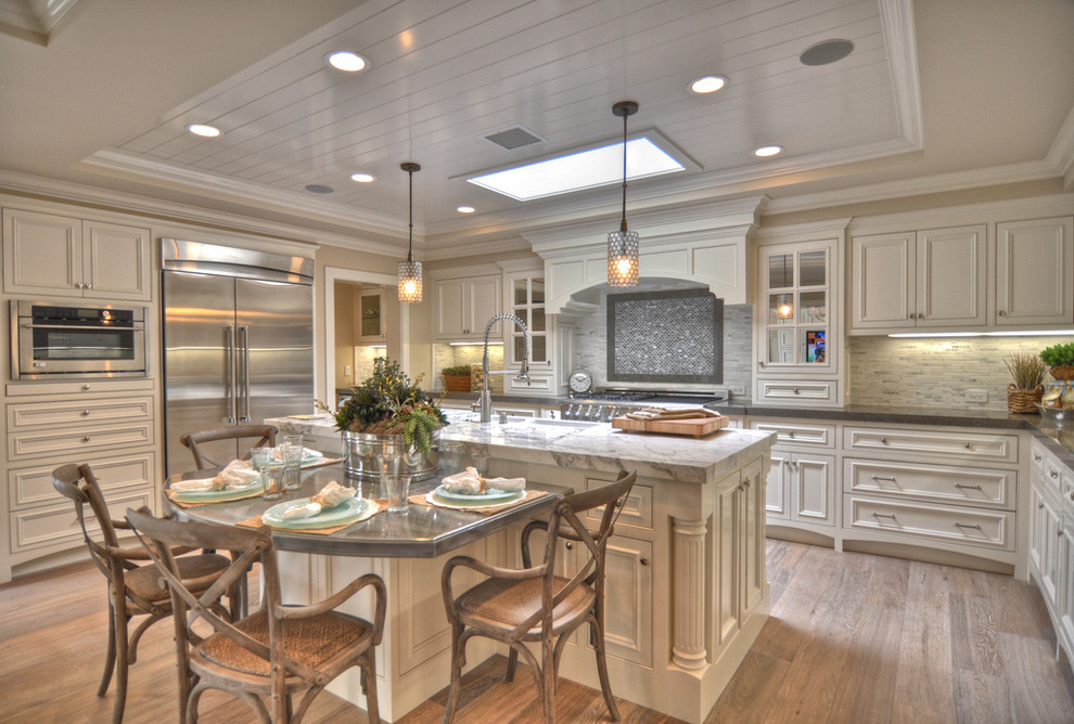 Photo of a beach style kitchen in Los Angeles with stainless steel appliances and marble benchtops.