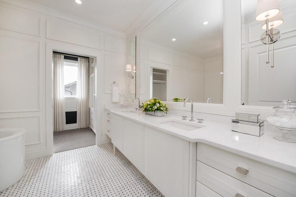 This is an example of a large transitional master bathroom in Calgary with an undermount sink, raised-panel cabinets, white cabinets, engineered quartz benchtops, a freestanding tub, an open shower, a one-piece toilet, multi-coloured tile, mosaic tile, white walls and mosaic tile floors.