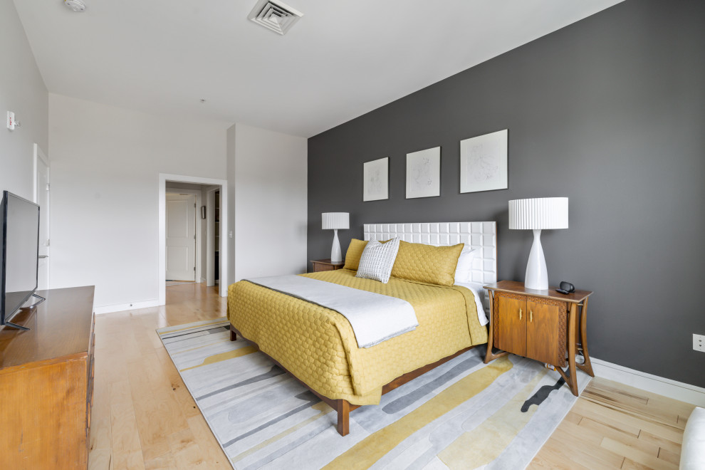 Imagen de dormitorio principal retro de tamaño medio con paredes grises y suelo de madera clara