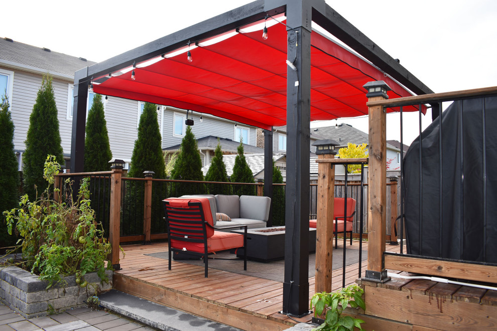Modern backyard deck in Toronto with a fire feature and a pergola.