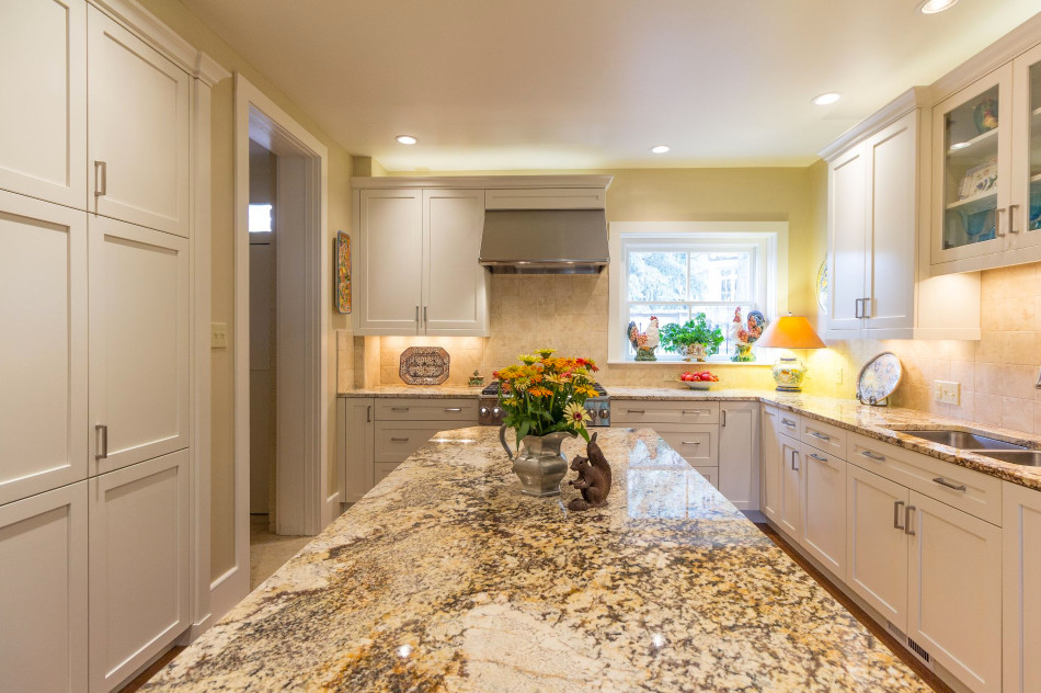 Example of a large transitional u-shaped brown floor and medium tone wood floor enclosed kitchen design in Denver with a double-bowl sink, shaker cabinets, white cabinets, granite countertops, beige backsplash, ceramic backsplash, stainless steel appliances and an island
