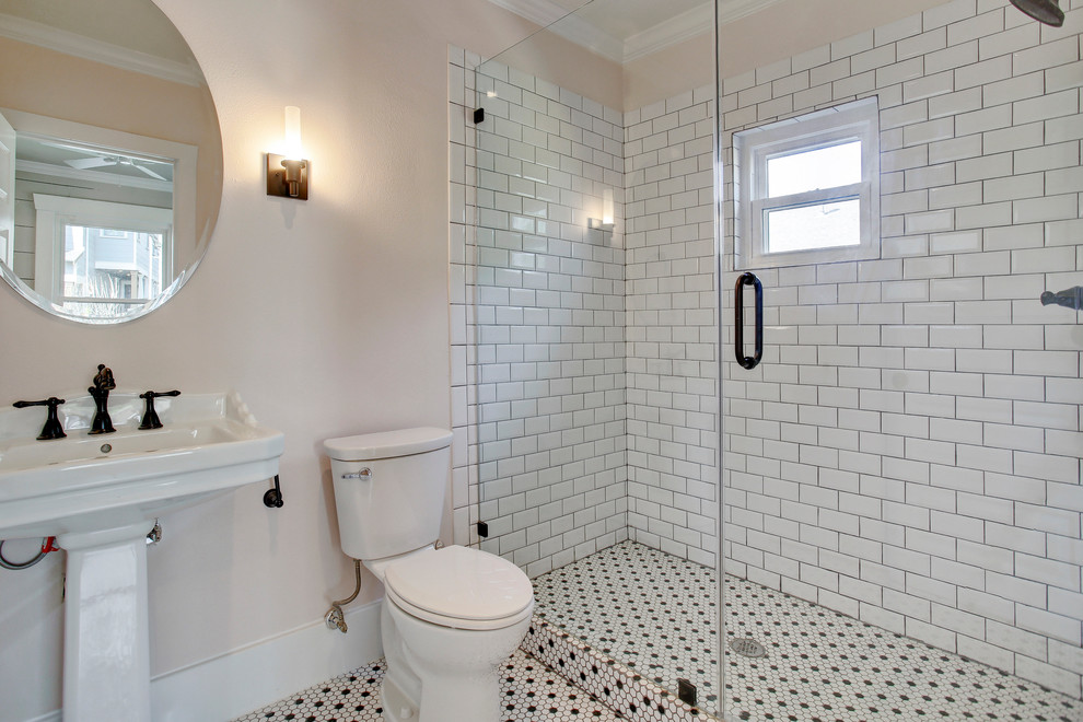 Design ideas for a mid-sized country bathroom in Houston with an alcove shower, a two-piece toilet, white tile, subway tile, beige walls, porcelain floors, a pedestal sink, white floor and a hinged shower door.