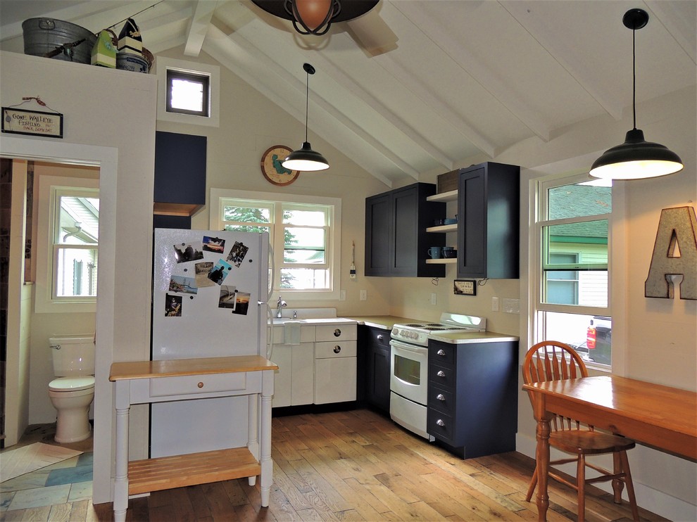 Inspiration for a small country u-shaped open plan kitchen in Other with shaker cabinets, blue cabinets, laminate benchtops, medium hardwood floors and no island.