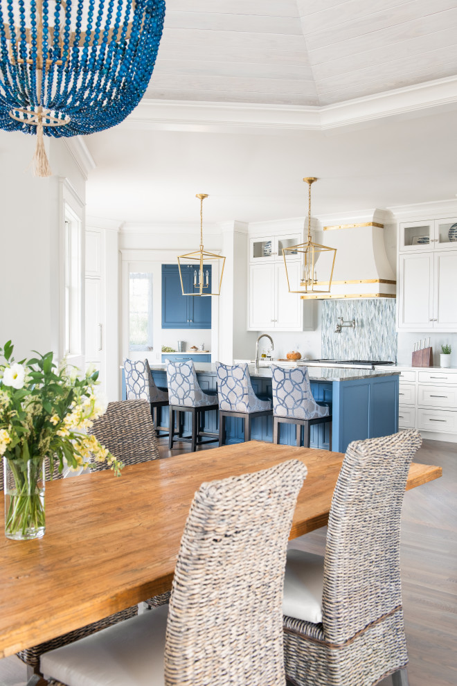 Inspiration for a beach style kitchen/dining combo in Charleston with white walls and light hardwood floors.