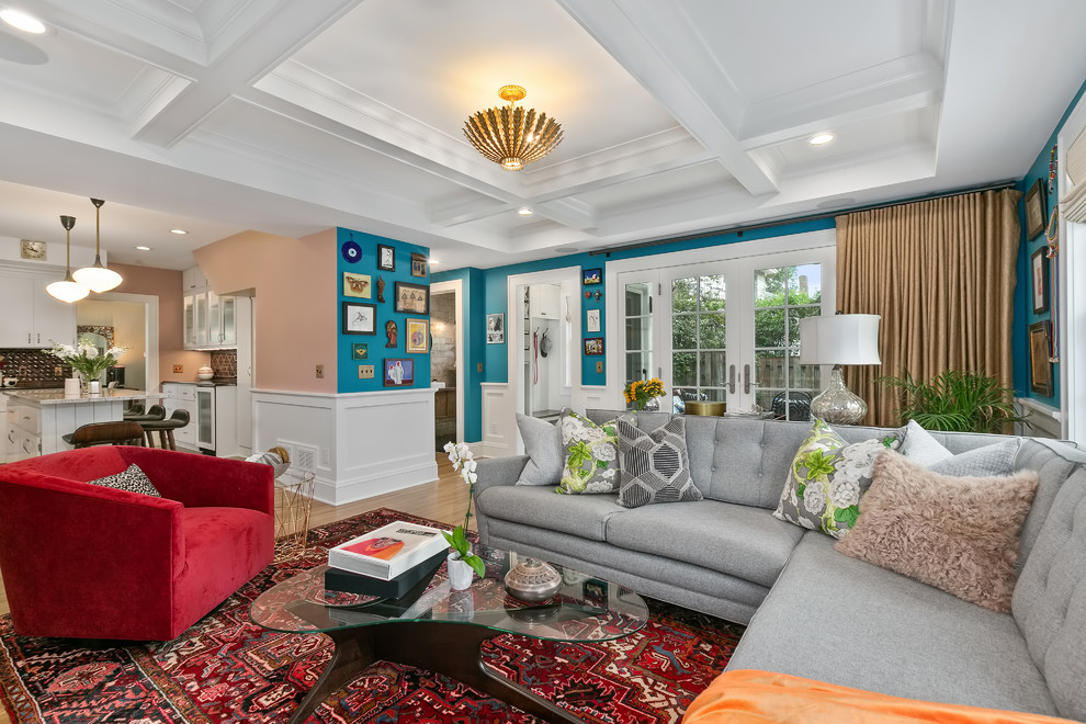 This is an example of a mid-sized eclectic open concept family room in Minneapolis with blue walls, light hardwood floors, a standard fireplace, a tile fireplace surround, a wall-mounted tv and yellow floor.
